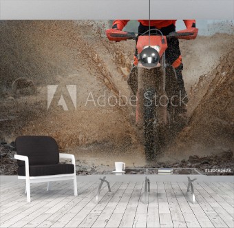 Picture of Motocross driver splashing mud on wet and muddy terrain
